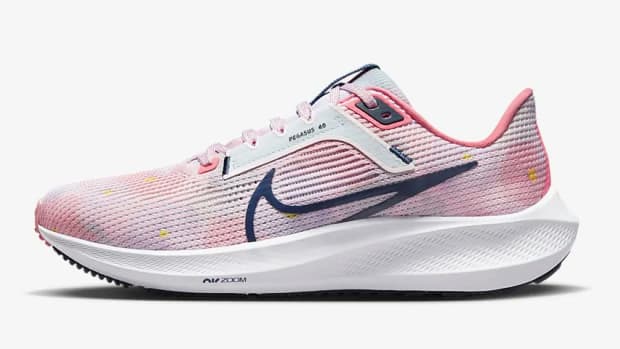 Side view of pink and navy Nike shoe.